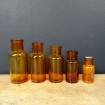 5 Amber-coloured antique glass bottles