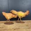 A wrought iron hen & rooster with a yellow patina