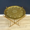 Coffee table with gilded brass top and folding wooden legs