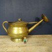 Large old brass watering can with apple
